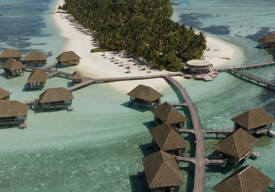 Bangalôs sobre a água no Club Med Kani, Maldivas, ligados por passarela ao atol de areia branca