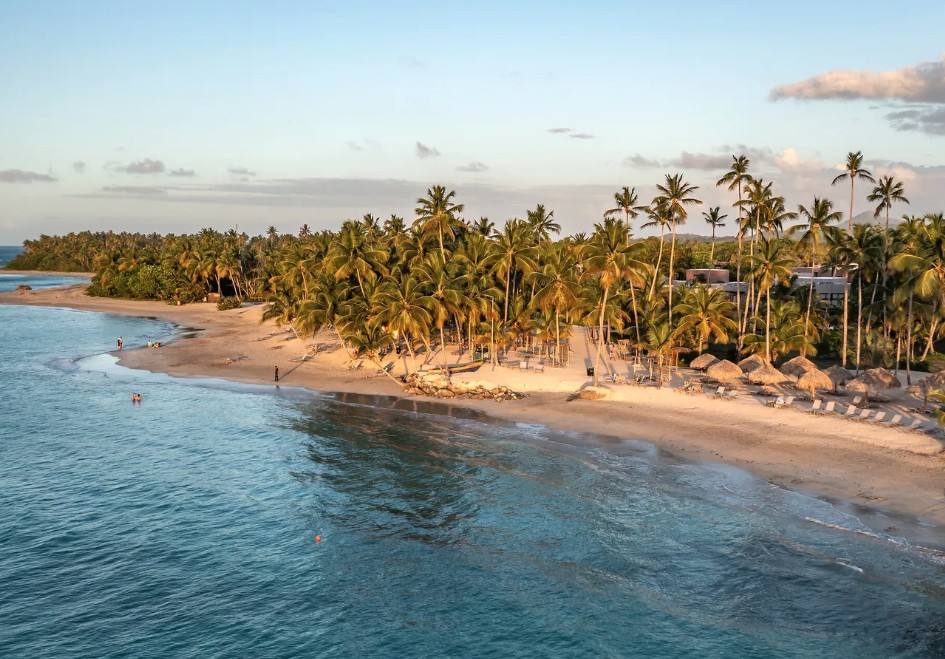 Praia de Miches Playa Esmeralda ao entardecer, com coqueiros, mar turquesa e palapas